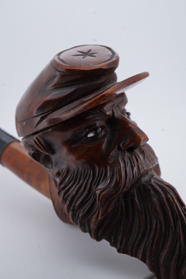 An American Civil War briar pipe in the form of the head of a bearded soldier, with horn mouthpiece, 23cm long